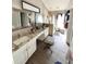 A bright and spacious bathroom with dual sinks, granite countertops, a walk-in shower, and wood look tile flooring at 12603 Midpointe, Riverview, FL 33578