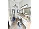 Bathroom featuring dual sinks, framed mirrors, a makeup vanity and wood look tile flooring at 12603 Midpointe, Riverview, FL 33578