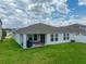 This home features a well-maintained backyard with lush green grass and a covered patio, perfect for enjoying the outdoors at 13105 Fruitville Way, Riverview, FL 33579
