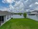 This home features a well-maintained backyard with lush green grass and a white vinyl fence at 13105 Fruitville Way, Riverview, FL 33579