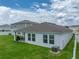 This home features a well-maintained backyard with lush green grass and a covered patio at 13105 Fruitville Way, Riverview, FL 33579