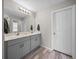 Bright bathroom featuring double sinks, modern fixtures, and stylish hardwood floors at 13105 Fruitville Way, Riverview, FL 33579