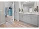 Elegant bathroom featuring double sinks, modern fixtures, and a doorway to a bedroom at 13105 Fruitville Way, Riverview, FL 33579