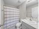 Neutral full bathroom features a shower with a striped curtain, a white vanity, and a matching toilet at 13105 Fruitville Way, Riverview, FL 33579