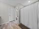 Bathroom featuring a shower with curtains, hardwood floors, and white door at 13105 Fruitville Way, Riverview, FL 33579