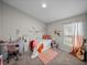 Bedroom with desk, accent wall decals, decorative lighting, and window with sheer curtains at 13105 Fruitville Way, Riverview, FL 33579