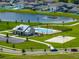 Aerial view of community pool, sand volleyball court, and resident parking area with pond view at 13105 Fruitville Way, Riverview, FL 33579