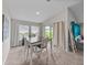 Bright dining area with neutral walls, large windows, sliding glass doors, and a rustic wood table at 13105 Fruitville Way, Riverview, FL 33579