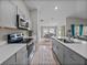 This kitchen features modern gray cabinets, quartz countertops, and seamlessly flows into the dining and living areas at 13105 Fruitville Way, Riverview, FL 33579