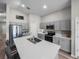 Bright kitchen with gray cabinets, quartz countertops, stainless steel appliances, and an island with barstool seating at 13105 Fruitville Way, Riverview, FL 33579