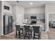 This kitchen features gray cabinets, quartz countertops, stainless steel appliances, and an island with barstool seating at 13105 Fruitville Way, Riverview, FL 33579