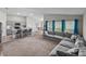Open-concept living room with gray sofa, kitchen island with bar stools, and vaulted ceiling, perfect for modern living at 13105 Fruitville Way, Riverview, FL 33579