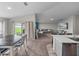 Open living space features a comfortable gray couch, large tv, and dining area with sliding glass door at 13105 Fruitville Way, Riverview, FL 33579