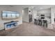 Open concept living room with gray sofa, a TV, and kitchen island with bar stools, seamlessly connected for modern living at 13105 Fruitville Way, Riverview, FL 33579