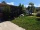 A partial view of the front yard with shrubs, sand bags, and palm trees at 13710 Frances Ave, Hudson, FL 34667