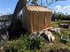 Exterior view of a backyard shed with a leaning tree at 13710 Frances Ave, Hudson, FL 34667