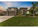 Elegant two-story home featuring lush landscaping, a manicured lawn, and an attached three-car garage at dusk at 1553 Canopy Oaks Blvd, Palm Harbor, FL 34683