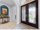 Welcoming foyer featuring a decorative glass double door, elegant rug, and stylish accent table at 1553 Canopy Oaks Blvd, Palm Harbor, FL 34683