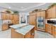Well-equipped kitchen featuring stainless steel double ovens, wood cabinets, and central island offering plenty of workspace at 1553 Canopy Oaks Blvd, Palm Harbor, FL 34683