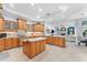 Spacious kitchen featuring wood cabinets, granite countertops, central island, and open layout perfect for entertaining at 1553 Canopy Oaks Blvd, Palm Harbor, FL 34683