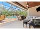 Inviting outdoor living space with a screened-in pool, bar area, and comfortable seating at 1553 Canopy Oaks Blvd, Palm Harbor, FL 34683