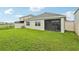Spacious backyard with lush lawn, screened lanai, and partial view of the lake at 15825 Mauvewood Ave, Odessa, FL 33556