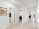 Bright hallway with tile floors connecting to a bathroom, office, and living spaces at 15825 Mauvewood Ave, Odessa, FL 33556
