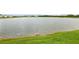 Scenic lake view surrounded by lush greenery and neighborhood homes under a bright sky at 15825 Mauvewood Ave, Odessa, FL 33556