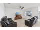 Cozy living room featuring reclining leather sofas, ceiling fan and a large television at 15825 Mauvewood Ave, Odessa, FL 33556