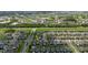 Drone view showcasing a vibrant community with winding roads, green spaces, and nearby golf course and waterways at 17156 Yellow Pine St, Wimauma, FL 33598