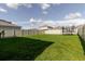Expansive backyard with lush green grass, surrounded by a privacy fence, providing ample space for outdoor activities at 17156 Yellow Pine St, Wimauma, FL 33598