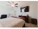 Comfortable bedroom features a ceiling fan, television, and dark wood furniture at 17156 Yellow Pine St, Wimauma, FL 33598