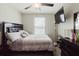 Bedroom featuring a ceiling fan, a window, and dark wood furniture at 17156 Yellow Pine St, Wimauma, FL 33598