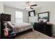 Bedroom featuring a ceiling fan, a mounted television, and dark wood furniture at 17156 Yellow Pine St, Wimauma, FL 33598