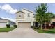 Charming two-story home featuring a well-manicured lawn, a two-car garage, and inviting landscaping at 17156 Yellow Pine St, Wimauma, FL 33598
