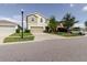Well-maintained two-story home with a two-car garage, complemented by mature trees and neat landscaping at 17156 Yellow Pine St, Wimauma, FL 33598