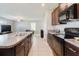 Modern kitchen with dark cabinets, stainless steel appliances, and an open layout with a center island at 17156 Yellow Pine St, Wimauma, FL 33598