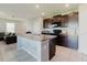 Open kitchen featuring dark cabinets, a center island, and views into the living area at 17156 Yellow Pine St, Wimauma, FL 33598