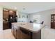 Open kitchen with granite counters, stainless sink, dark wood cabinets, flowing to the dining area with natural light at 17156 Yellow Pine St, Wimauma, FL 33598