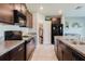 Bright kitchen with dark cabinetry, granite counters, and views into the dining area and pantry at 17156 Yellow Pine St, Wimauma, FL 33598