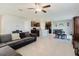 Living room featuring tile flooring, a ceiling fan, and an open layout with the kitchen at 17156 Yellow Pine St, Wimauma, FL 33598