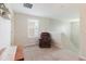 Cozy upstairs loft space with neutral carpet, a comfortable recliner, and natural light from a window at 17156 Yellow Pine St, Wimauma, FL 33598