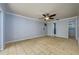 Large bedroom with tile floors, ceiling fan, and a door leading to the en-suite bathroom at 17807 Fallowfield Dr, Lutz, FL 33549