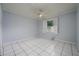 A bright bedroom with a ceiling fan and white tile flooring at 17807 Fallowfield Dr, Lutz, FL 33549
