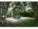 Secluded front yard featuring a garden bench and mature trees offering plenty of shade at 17807 Fallowfield Dr, Lutz, FL 33549
