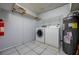 A simple laundry room with washer, dryer, and hot water tank at 17807 Fallowfield Dr, Lutz, FL 33549