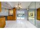 Open-concept floorplan featuring tile flooring, chandelier, kitchen access, and views of the pool at 17807 Fallowfield Dr, Lutz, FL 33549