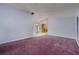 Cozy living room with purple carpeting and a mirrored wall that creates a feeling of spaciousness at 17807 Fallowfield Dr, Lutz, FL 33549