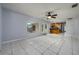 Open-concept living area with tile floors, leading to the kitchen and views of the backyard pool at 17807 Fallowfield Dr, Lutz, FL 33549