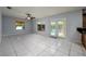 Spacious living room with bright tile floors, a ceiling fan, and doors leading to the pool at 17807 Fallowfield Dr, Lutz, FL 33549